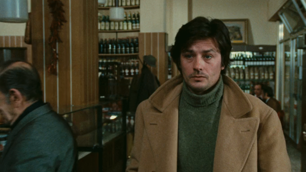 Personaggio con cappotto beige con lo sguardo malinconico
