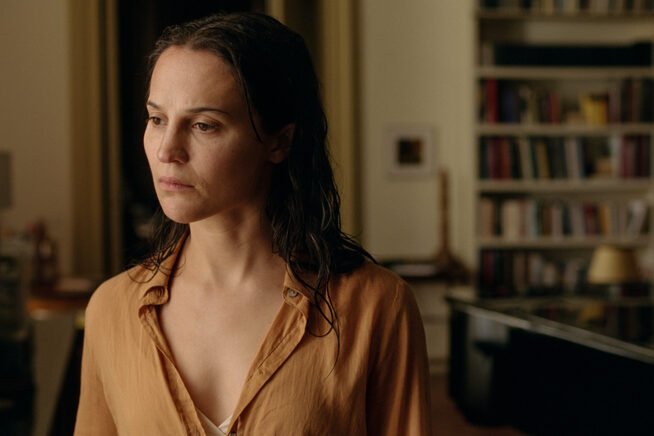 Anne (Alicia Vikander) da sola nell'appartamento di Leo in una scena del film The Echo Chamber di Andrea Pallaoro